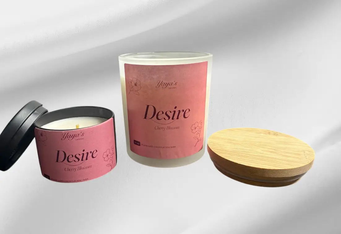 Two candles from Yaya's line, "Desire" in Cherry Blossom scent. One is cylindrical with a wooden lid, the other is a smaller tin.