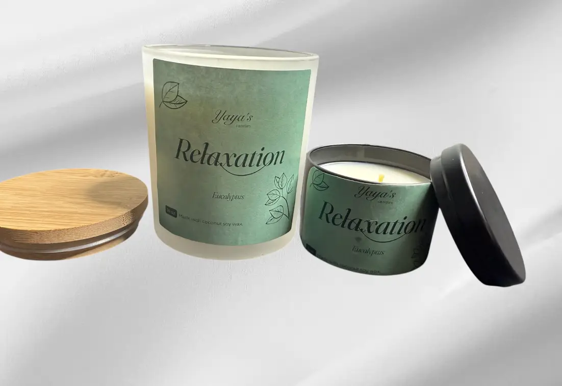 Two candles labeled "Relaxation" in eucalyptus scent, one glass with a wooden lid and one metal tin, on a soft gray background.