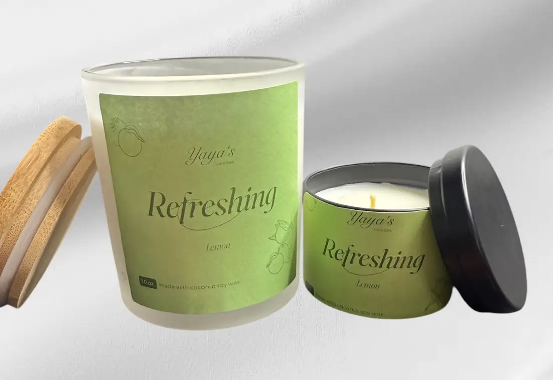 Two lemon-scented candles by Yaya's, one in a glass jar with a bamboo lid and the other in a metal tin, both labeled "Refreshing."